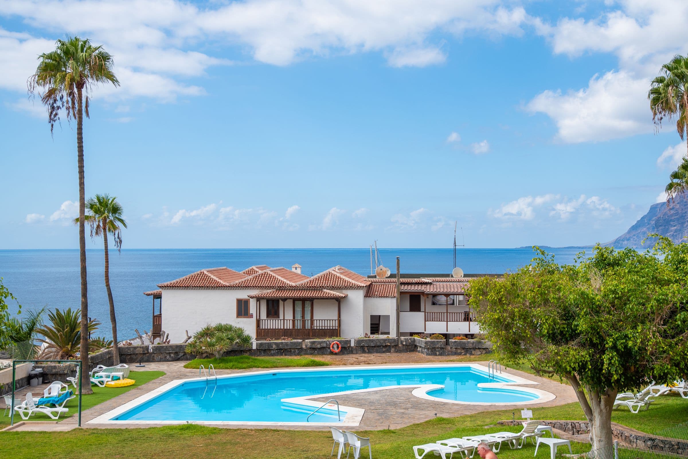 Poolanlage der Wohnanlage mit Palmen und Meer